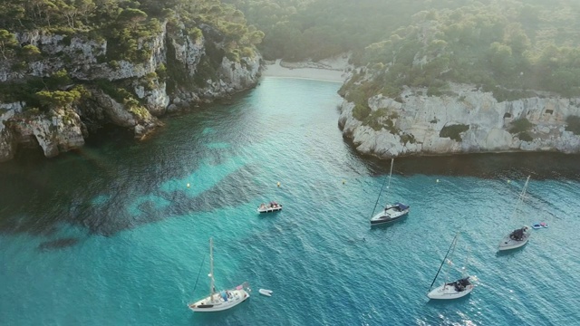 西班牙米诺卡岛，卡拉·马卡雷雷塔与船只的鸟瞰图视频下载