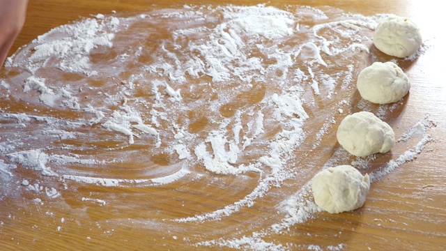 女人的手在厨房的桌子上做发面面包。视频素材