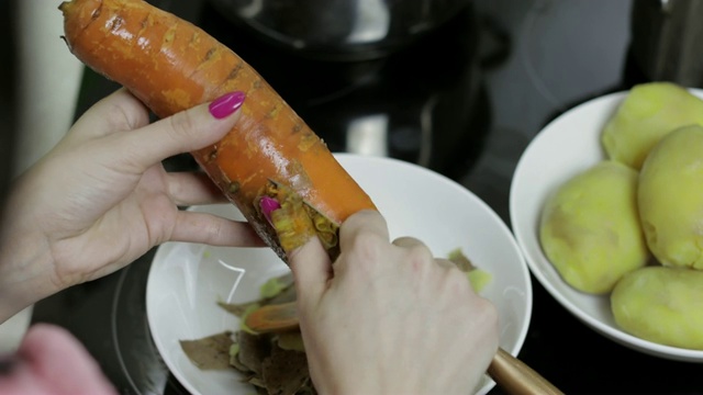 女家庭主妇在厨房用手削胡萝卜。视频素材