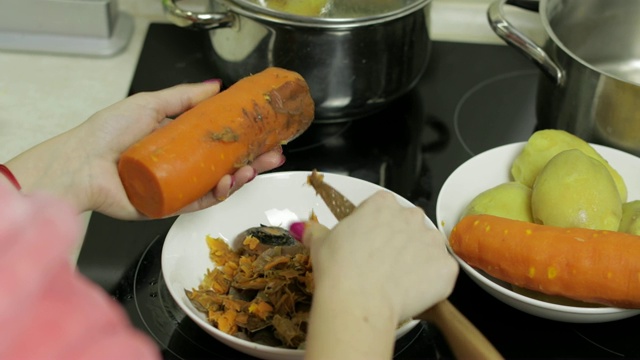 女家庭主妇在厨房用手削胡萝卜。视频素材