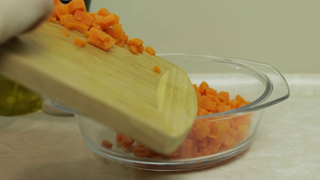 女主妇用手把胡萝卜片放进沙拉盘里视频素材