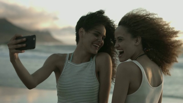 女性朋友在多风的海滩自拍视频素材