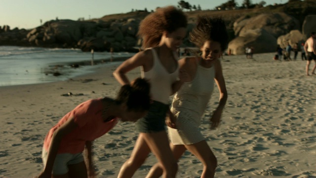 快乐的女性朋友在海滩上跑步视频素材