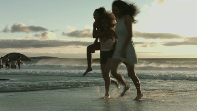 女性朋友度假时在海滩上跑步视频素材