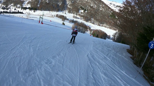 一个年轻的滑雪者从法国比利牛斯山的滑雪坡上下来视频素材