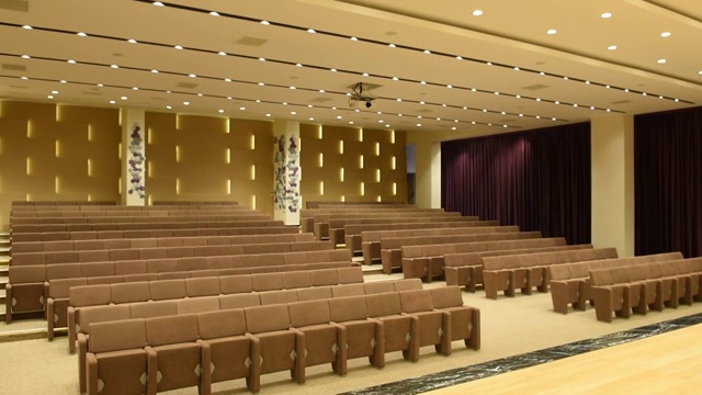 在空无一人的会议大厅里，灯开着/关着，有一排排供观众和观众使用的座位。视频下载
