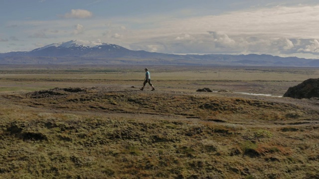 一名男子走在冰岛悬崖上的航拍照片视频素材