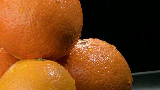新鲜的橙子水果旋转在黑色的背景视频素材