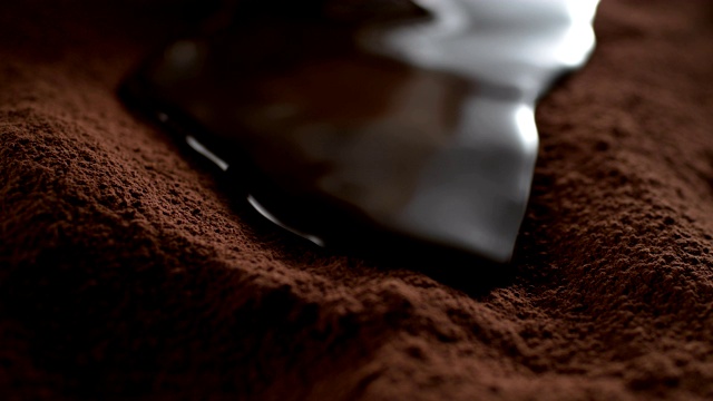 液态巧克力在可可粉上流动。超级慢动作视频下载