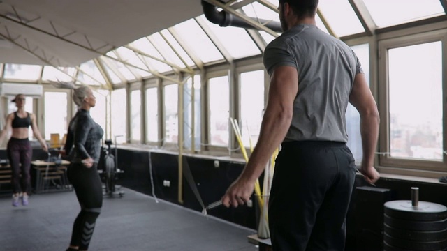 女士和男子健身教练训练与跳绳在健身房视频素材