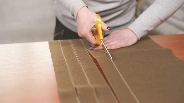 裁缝用剪刀根据图案裁剪棕色高质量织物的条纹视频素材