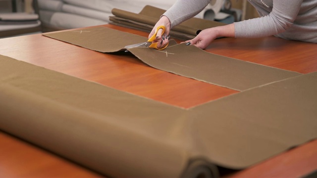 裁缝用专业剪刀剪出高质量的棕色材料视频素材