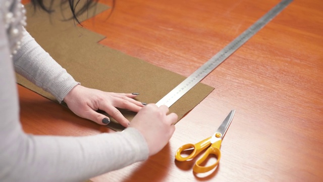 裁缝用尺子在材料上用粉笔做一个图案。纺织制造业的概念视频素材
