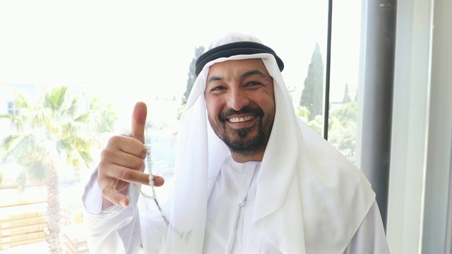自信的阿拉伯商人在办公室里竖起大拇指的肖像视频下载