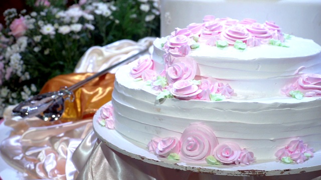 镜头:美丽的婚礼蛋糕，在婚宴上装饰着鲜花。视频素材