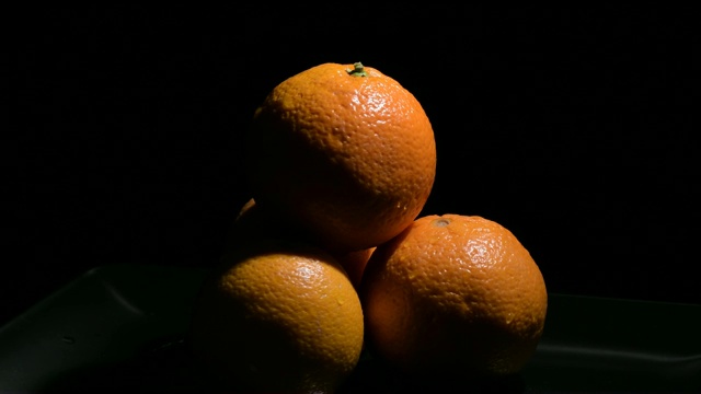 新鲜的橙子，天然的水果在黑色的背景上旋转视频素材