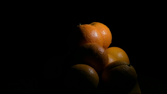 天然橙子，新鲜水果在黑色背景上旋转视频素材