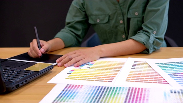 平面室内设计师选择颜色从样本样本。创造性的人在现代办公室用数字平板电脑和手写笔画画。商业、技术、设计和人的理念视频素材