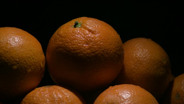 橙子，在黑色背景上旋转的天然水果视频素材