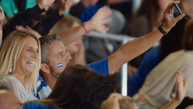 一男一女在用智能手机拍摄一段自己在论坛上的体育赛事视频视频素材