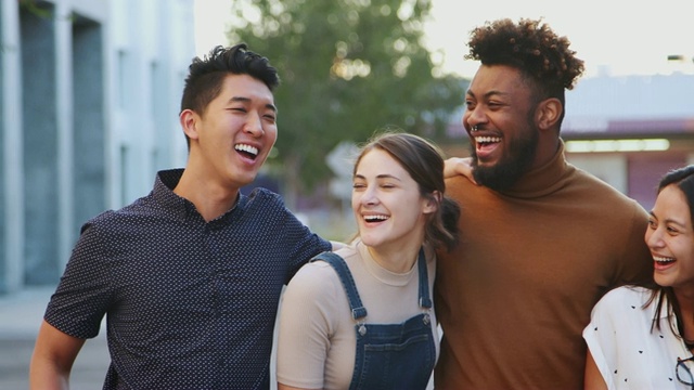 六位千禧一代潮人朋友站在城市街道上对着镜头微笑，摇拍视频素材