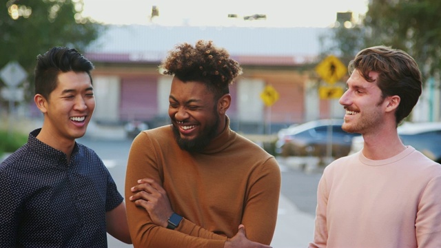 三个年轻的成年男性朋友站在城市街道上对着镜头微笑，正面，特写视频素材