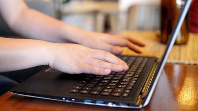女人用手在笔记本电脑键盘上打字，滑块右移，慢动作视频素材