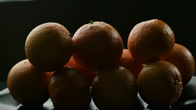 山的新鲜和天然的橘子水果旋转在黑色的背景视频素材