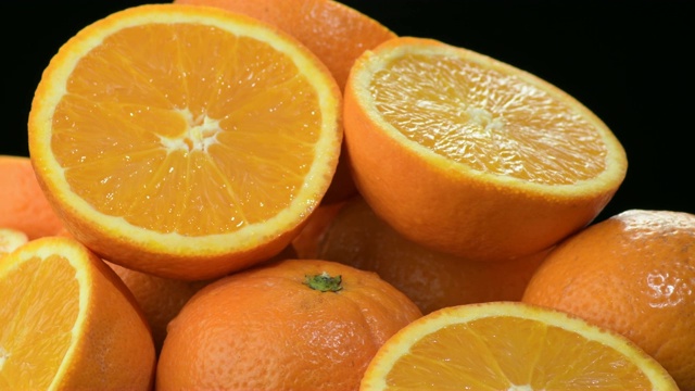 山一样的新鲜橙子被切好，整个在旋转视频素材
