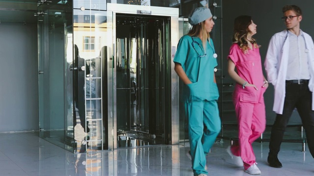 三个医护人员走在医院的走廊上视频素材