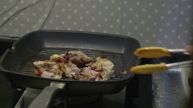 在煎锅里煎鸡的女人视频素材