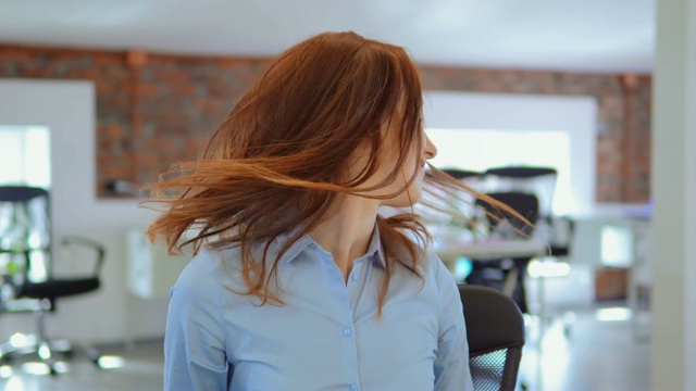 开朗的红发女商人在工作场所摆姿势视频素材