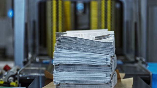 一叠叠刚从堆积机里打印出来的报纸视频素材