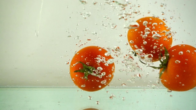 西红柿落在水中。缓慢的运动。视频素材