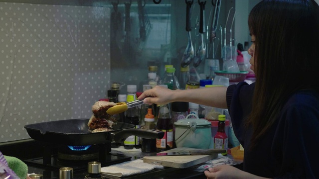 在煎锅里煎鸡的女人视频素材