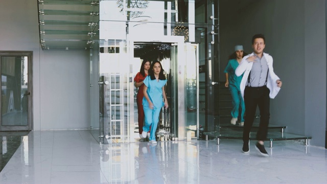 一队医务人员在医院走廊里急匆匆地奔忙着视频素材