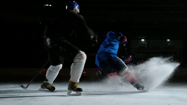 两个男人在溜冰场打曲棍球。两名冰球运动员为冰球而战。替身拍摄视频素材