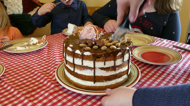 刀切节日蛋糕。桌上放着一块节日蛋糕。他手里拿着一把刀正在切巧克力蛋糕。视频下载