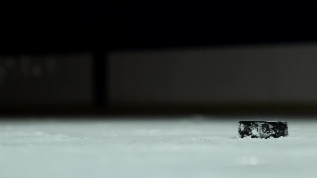 特写慢动作冰球和飞雪，冰球运动员拿起冰球棒视频素材
