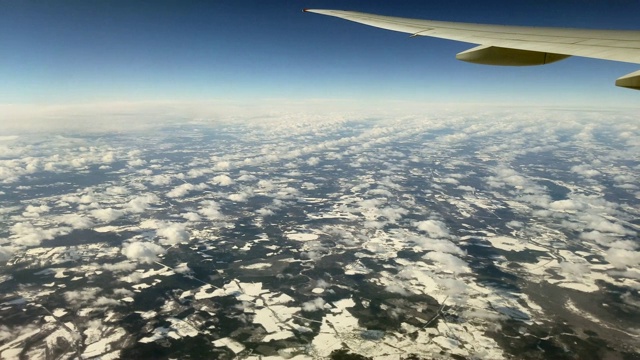 这架客机在冬天飞过陆地和云层视频素材
