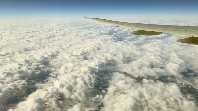 这架客机在冬天飞过陆地和云层视频素材