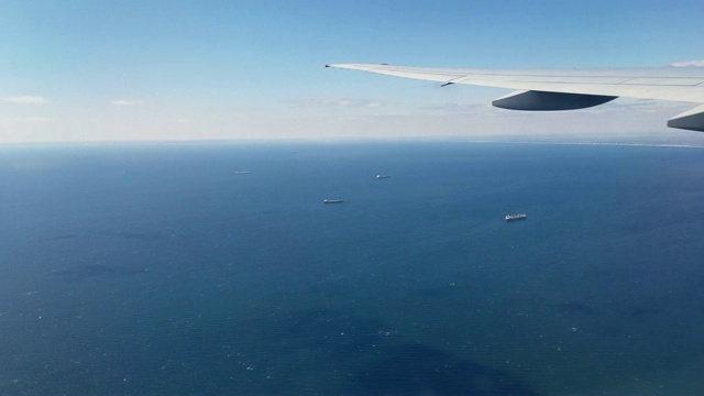 客机在长岛附近的大西洋上空飞行，商业货船在那里。视频素材