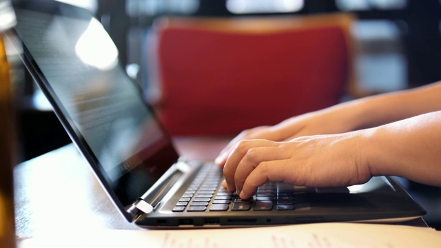 在咖啡馆工作的女人用笔记本电脑打字，慢动作视频素材