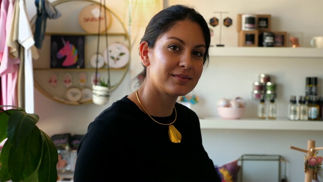 女企业主微笑着站在精品店的肖像视频下载