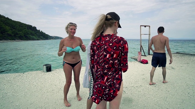 有趣的女性朋友度假用智能手机在海滩上自拍，慢动作视频素材