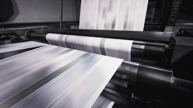 在报纸印刷厂，纸张在机器上快速移动视频下载