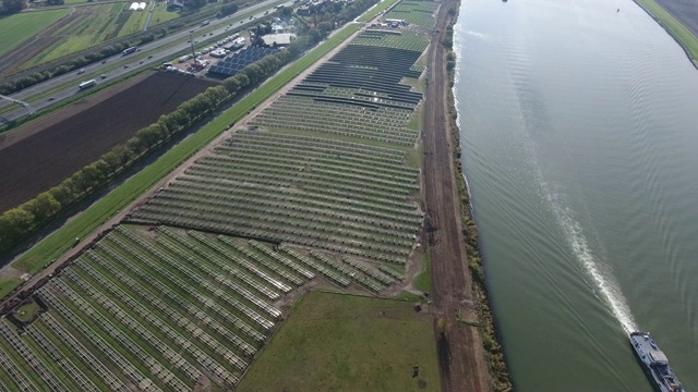 航拍的未完成的太阳能电池板场周围的河流与帆船视频素材