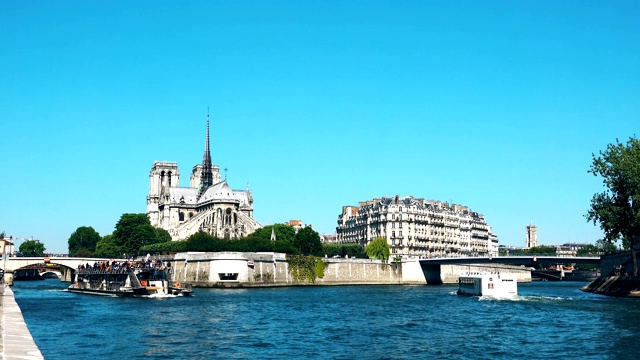 巴黎圣母院和塞纳河与船在阳光明媚的日子视频素材