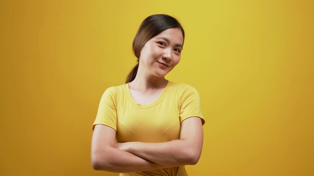 快乐的女人看着相机在孤立的黄色背景视频下载