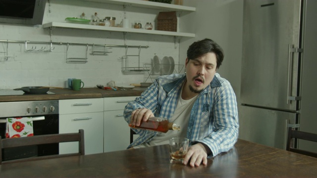 一个男人坐在餐桌前喝酒视频素材